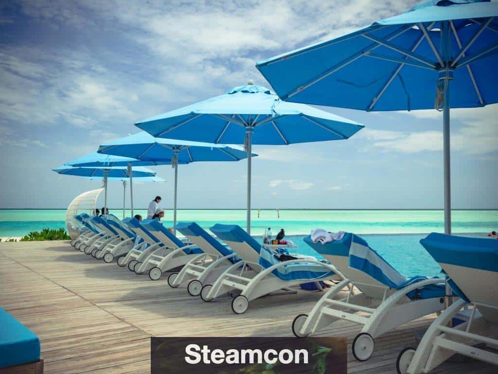 Collection of contemporary deck chairs under umbrellas located on wooden terrace in front of blue sea in summer